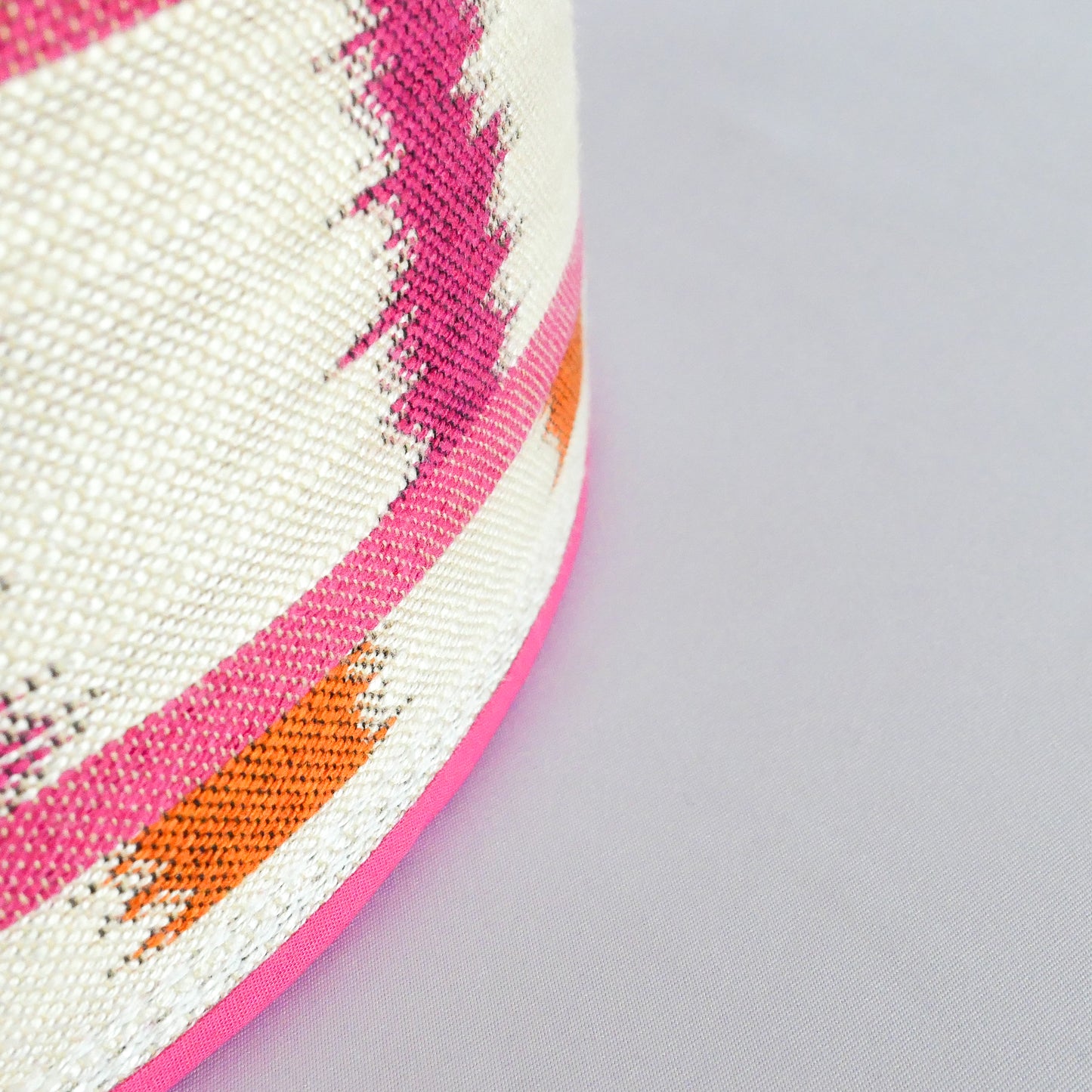 Close-up of a colorful fabric with pink and orange stripes and a pink rim