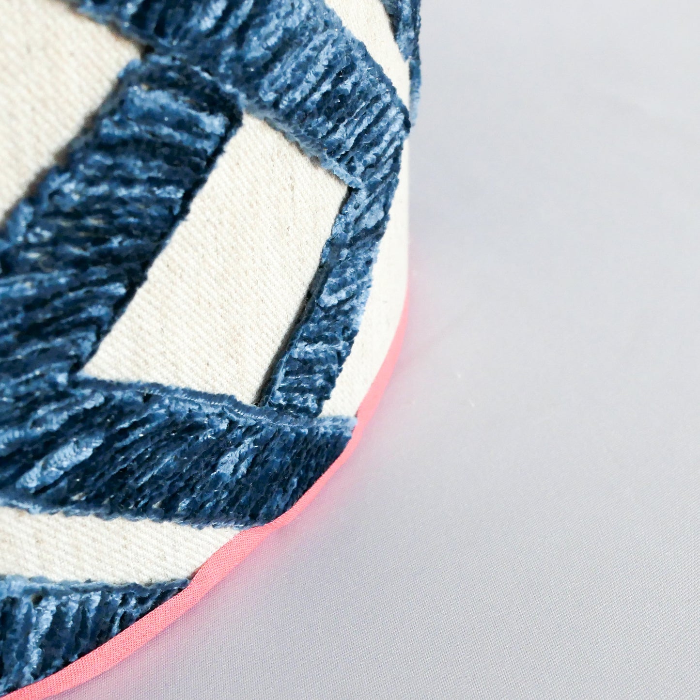 Close-up of a textured blue and white patterned lampshade with an orange border.