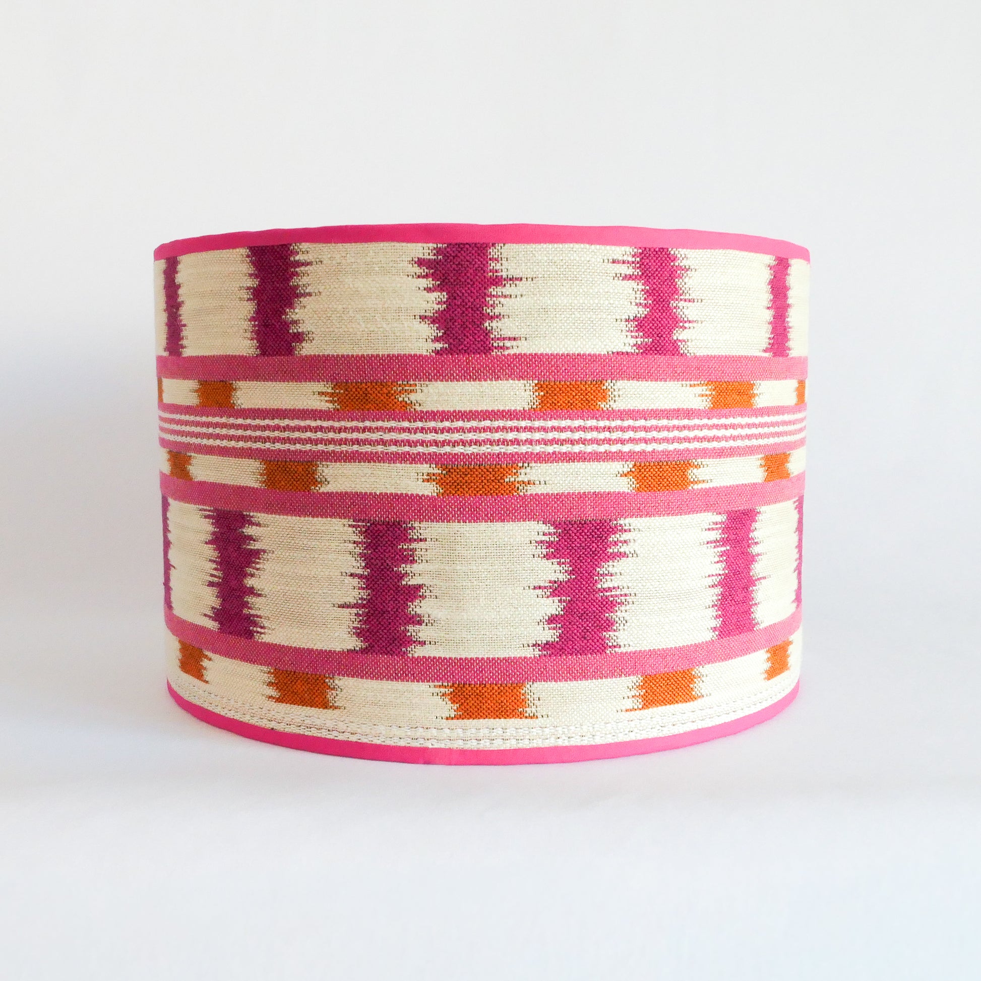 Front view of a lampshade with a pink, orange and white pattern and a pink rim