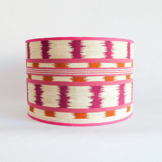 Front view of a lampshade with a pink, orange and white pattern and a pink rim