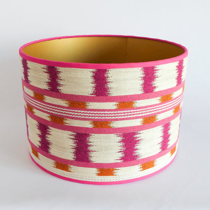 Top view of a lampshade with a pink, orange and white pattern, a gold interior and a pink rim