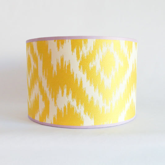 Front view of a yellow and white patterned lampshade with a lila rim