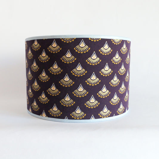 Front view of a purple lampshade featuring gold patterns and with a light blue rim.