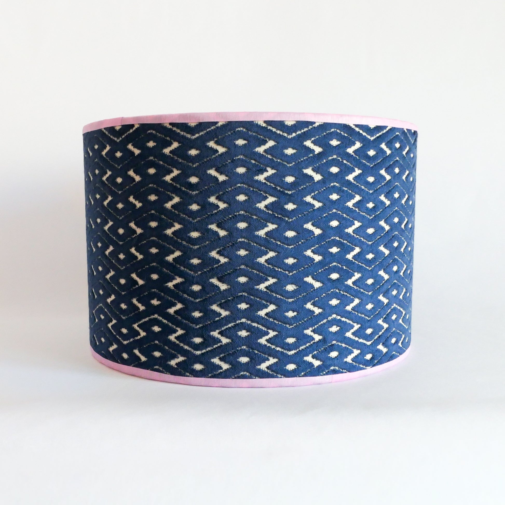 Front view of a blue patterned lampshade with a lila rim
