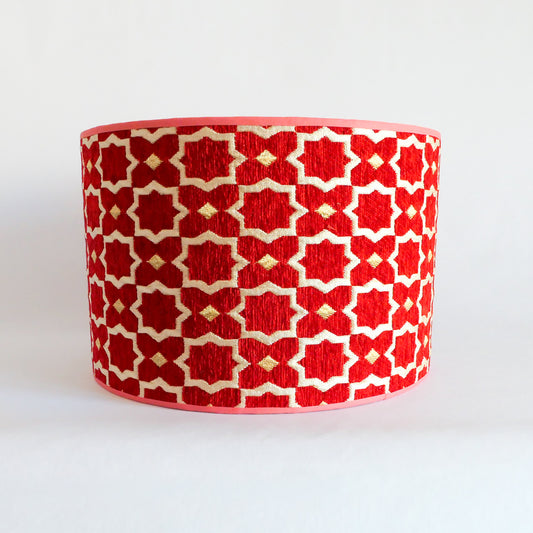Front view of a red and white patterned lampshade on a white background