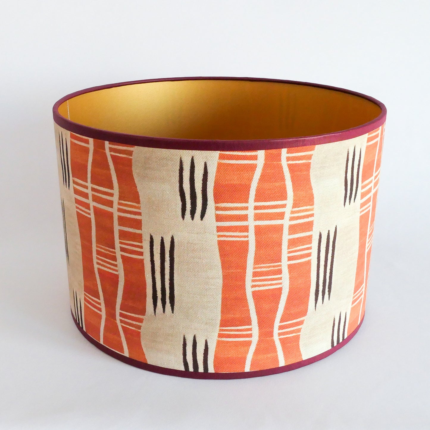 Top view of a lampshade with an African pattern with a golden interior on a white background