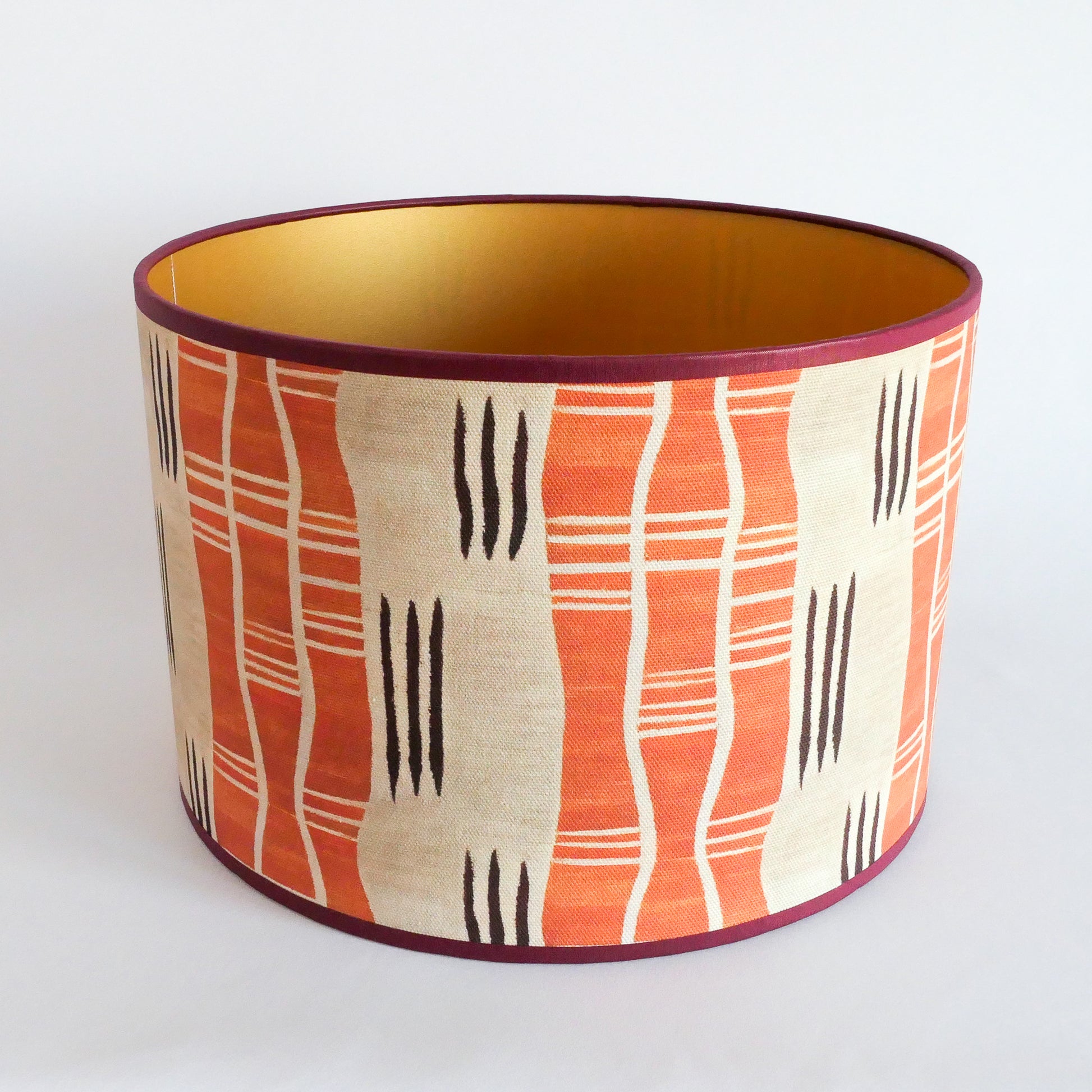 Top view of a lampshade with an African pattern with a golden interior on a white background