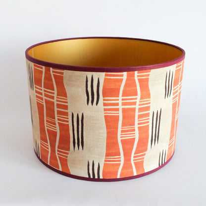 Top view of a lampshade with an African pattern with a golden interior on a white background