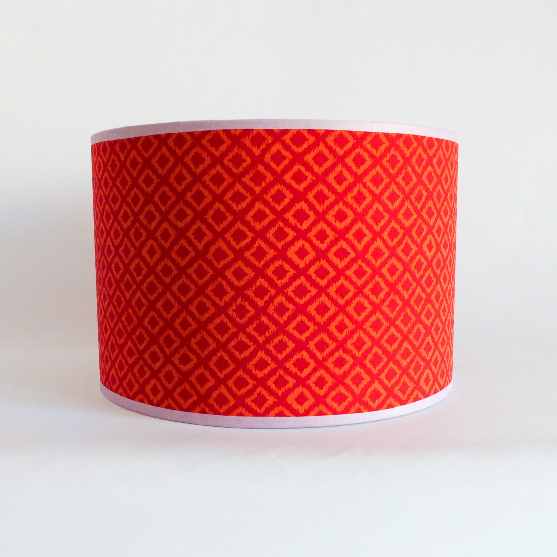 Front view of a red patterned lampshade on a white background