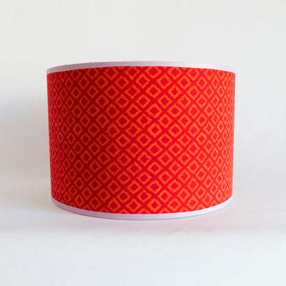 Front view of a red patterned lampshade on a white background