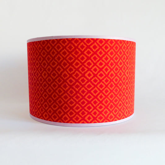 Front view of a red patterned lampshade on a white background